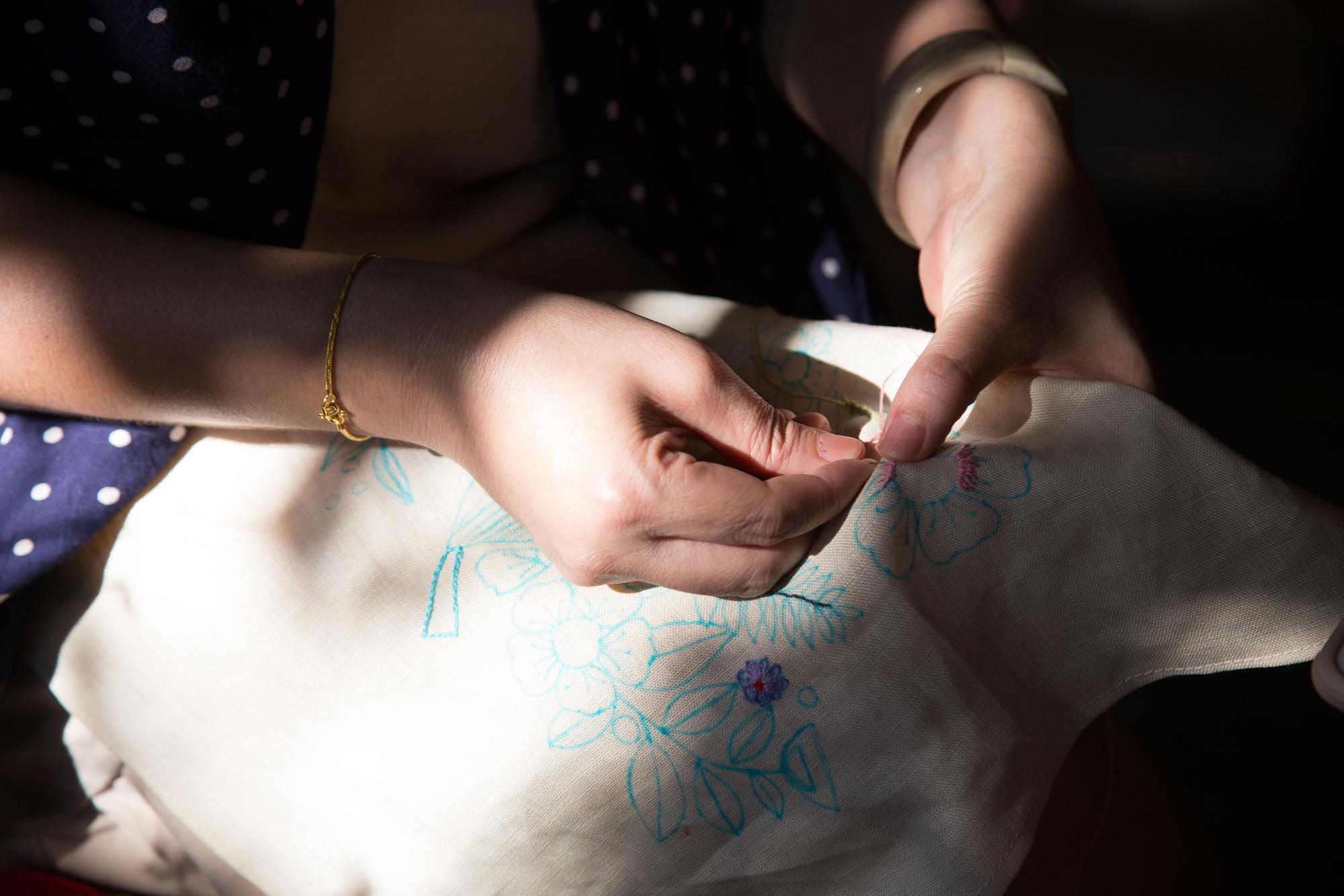 Artisan stitching a floral motif